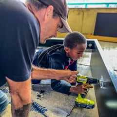 An officer and a child building a desk together