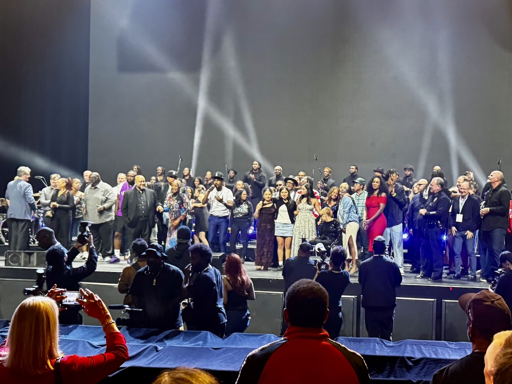 The company of Nothing to See Here: Watts on stage under the house lights, photographers at the lip of the stage