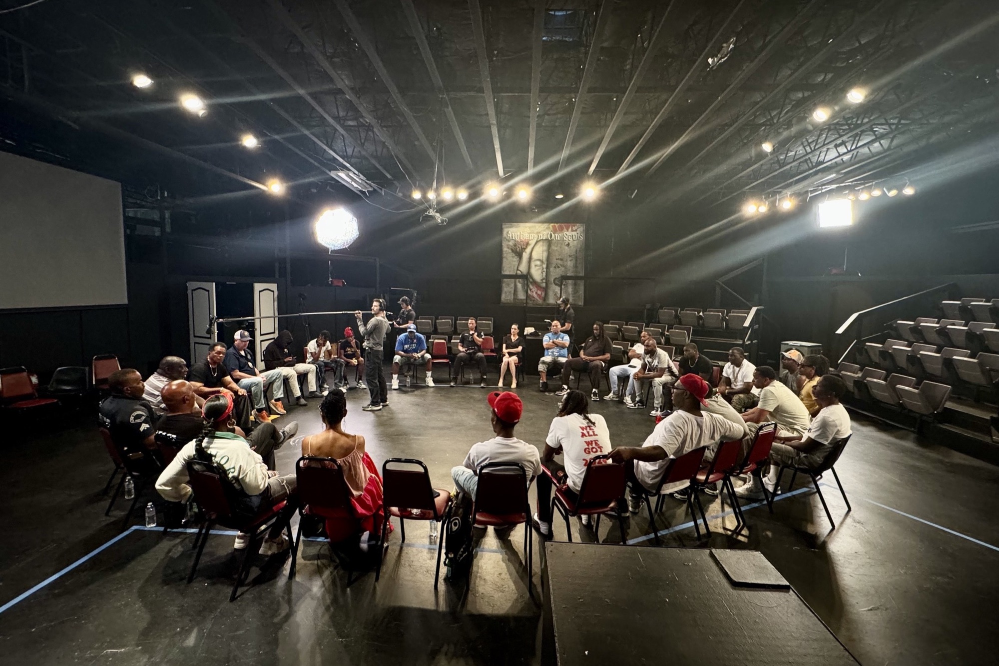 The filmmakers in discussion, seated in a circle of chairs in a darkened theatre.