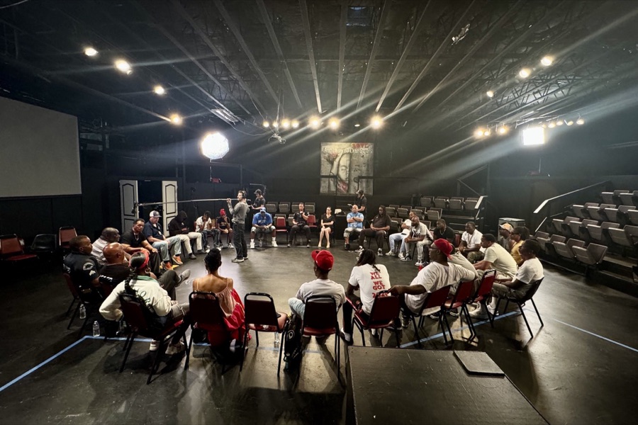 The filmmakers in discussion, seated in a circle of chairs in a darkened theatre.
